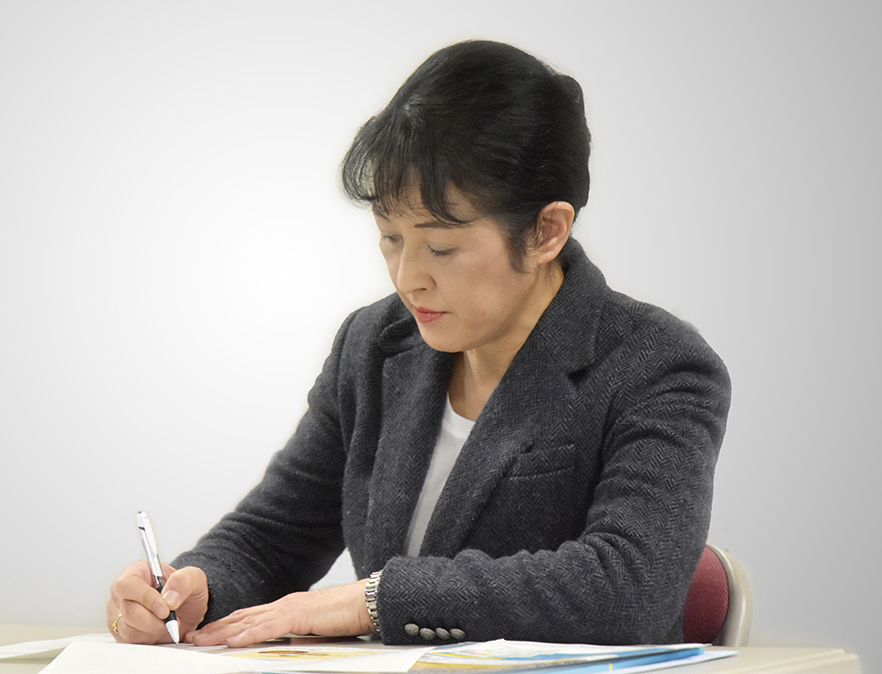 佐藤代表理事のお話を伺いながら、メモをとる飯田先生